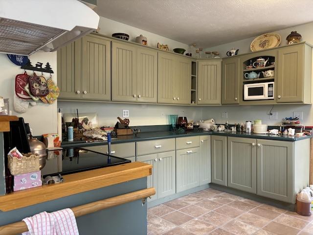 kitchen with open shelves, dark countertops, exhaust hood, green cabinetry, and white microwave