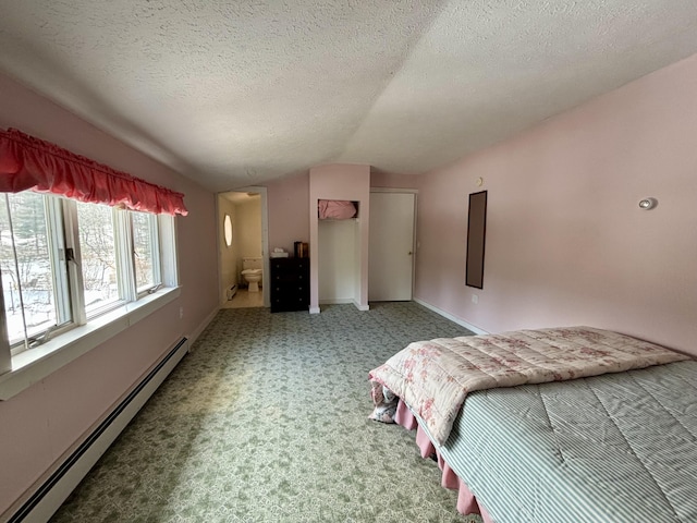 6658 M-33, Onaway, MI 49765 - carpeted bedroom with ensuite bathroom, a textured ceiling, a baseboard radiator, baseboards, and vaulted ceiling