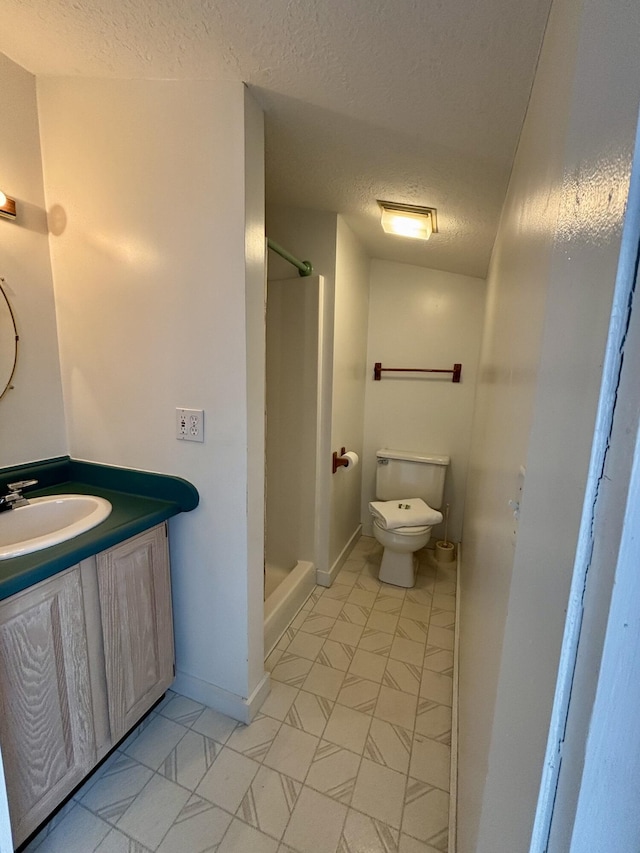 6658 M-33, Onaway, MI 49765 - full bathroom with toilet, a textured ceiling, baseboards, walk in shower, and vanity