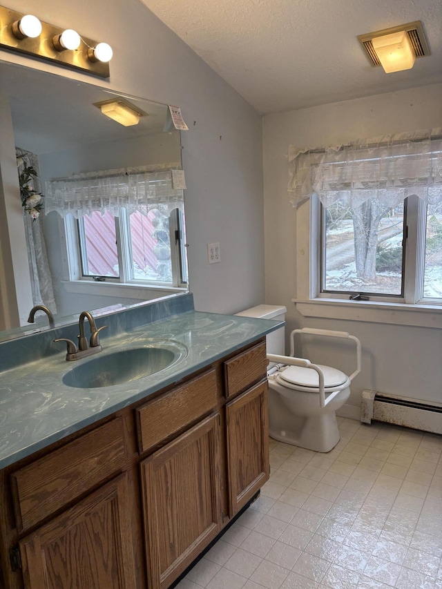 6658 M-33, Onaway, MI 49765 - full bath featuring a baseboard radiator, toilet, visible vents, and vanity