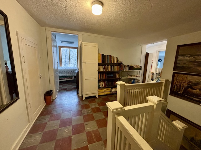6658 M-33, Onaway, MI 49765 - corridor featuring an upstairs landing, a textured ceiling, and dark floors