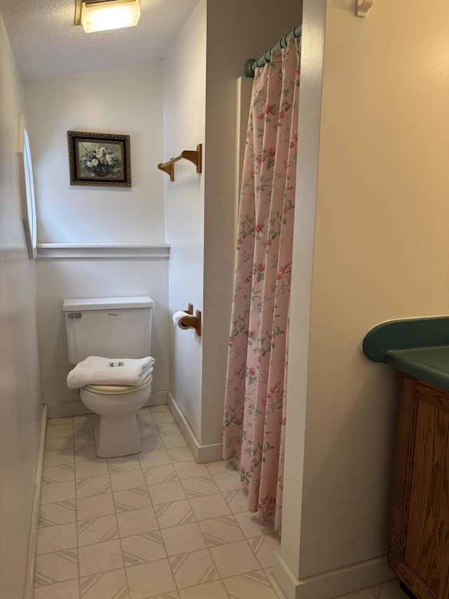 6658 M-33, Onaway, MI 49765 - full bath featuring a shower with curtain, baseboards, and toilet