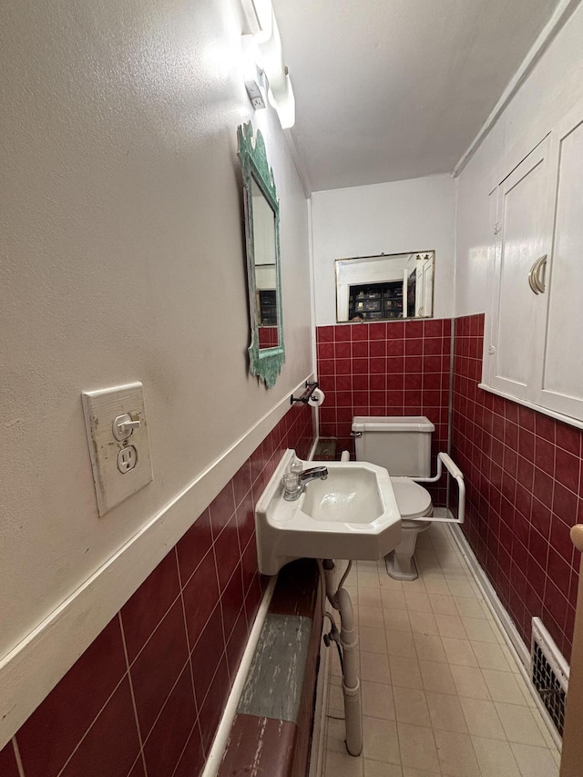 6658 M-33, Onaway, MI 49765 - bathroom with visible vents, toilet, a sink, tile walls, and tile patterned flooring