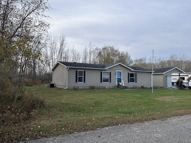 manufactured / mobile home featuring a front yard and a detached garage