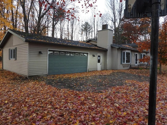 view of property exterior featuring a chimney and an attached garage