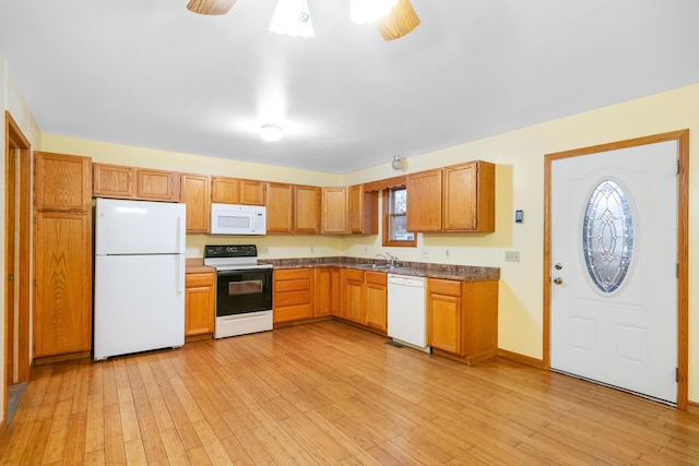 4963 Eastway Dr, Indian River, MI 49749 - kitchen with white appliances, light wood-style flooring, dark countertops, and a sink