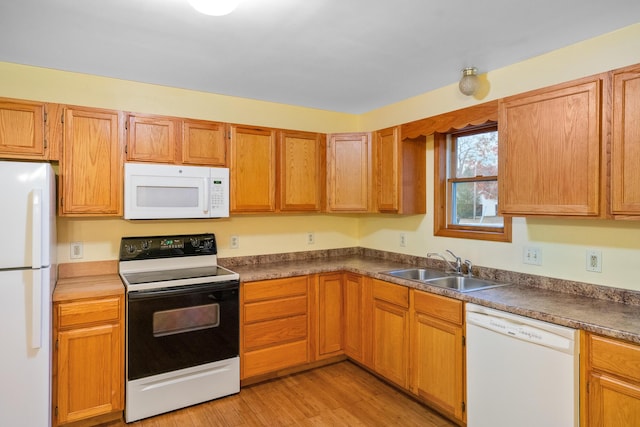 4963 Eastway Dr, Indian River, MI 49749 - kitchen featuring a sink, light wood-type flooring, white appliances, and dark countertops