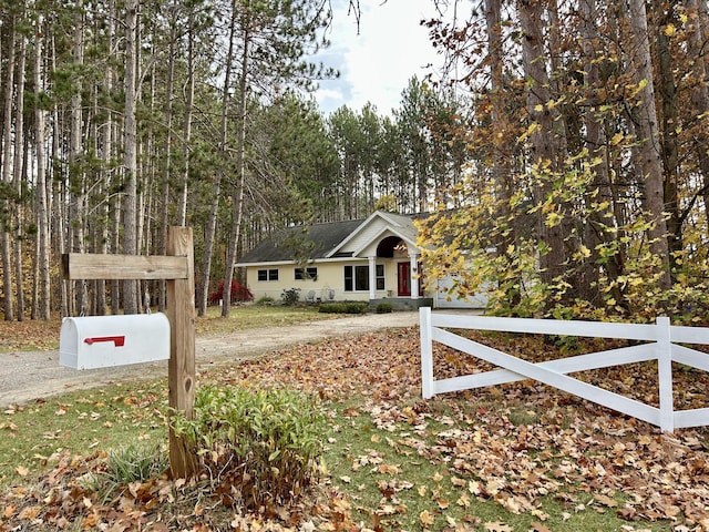 view of front of home with driveway and fence