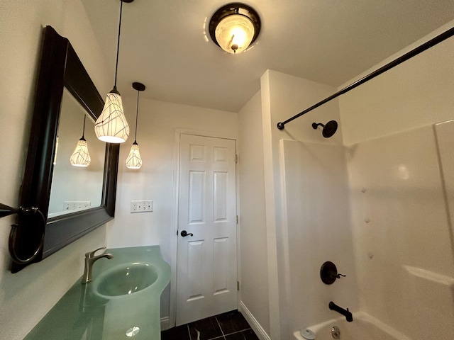 bathroom with a sink, baseboards, and bathtub / shower combination