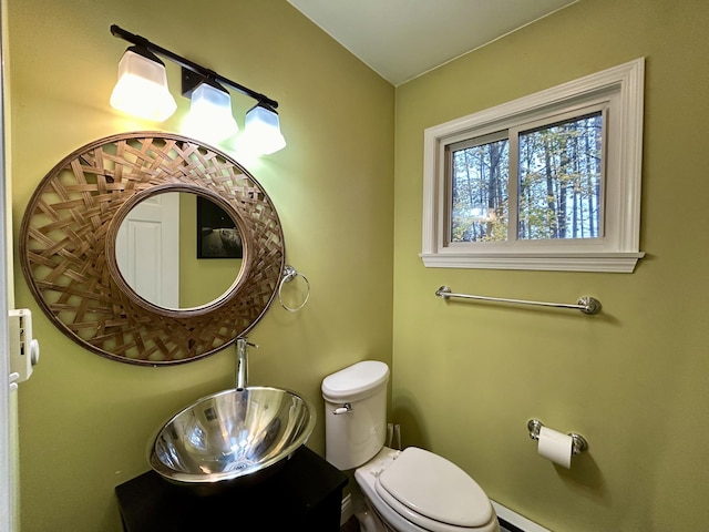 bathroom featuring a baseboard radiator, toilet, and a sink