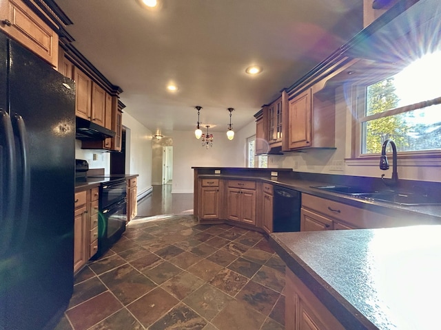 kitchen featuring a peninsula, a sink, black appliances, under cabinet range hood, and dark countertops