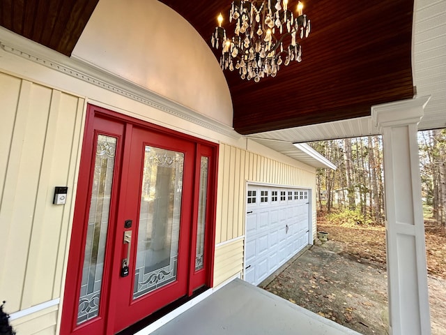 view of exterior entry with board and batten siding and a garage