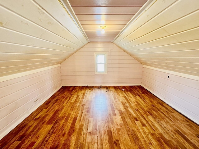 additional living space with vaulted ceiling, wood walls, wooden ceiling, and hardwood / wood-style floors