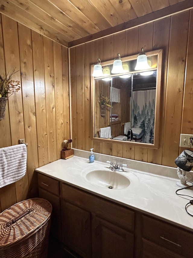 full bath featuring wooden ceiling, vanity, and wood walls