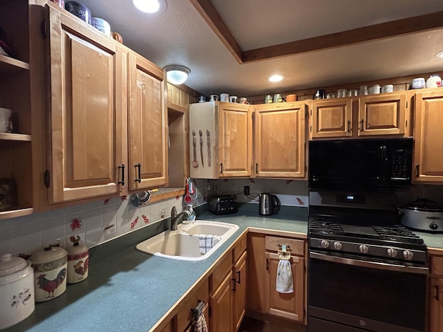 kitchen with a sink, tasteful backsplash, stainless steel range with gas cooktop, black microwave, and light countertops