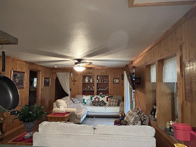 carpeted living room with wood walls and ceiling fan