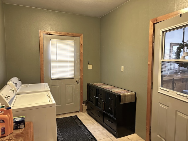 laundry area with laundry area, light tile patterned floors, a healthy amount of sunlight, and washer and clothes dryer