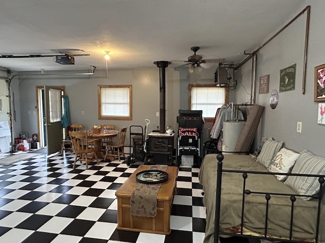 interior space with ceiling fan, a garage door opener, and a wood stove