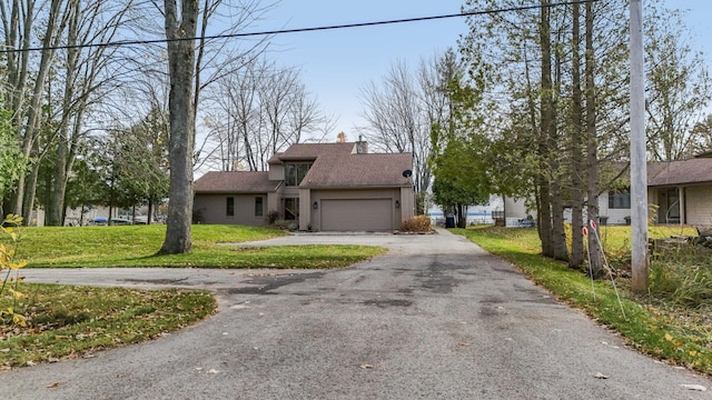 view of front of house with a front yard, a garage, driveway, and a chimney