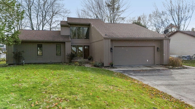 view of front of home with an attached garage, driveway, a front lawn, and roof with shingles