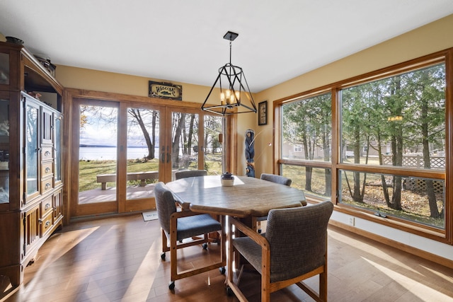 sunroom / solarium featuring plenty of natural light and an inviting chandelier