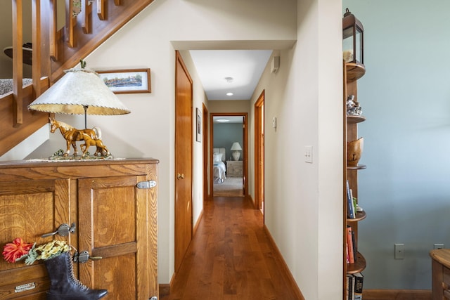 corridor featuring baseboards and wood finished floors