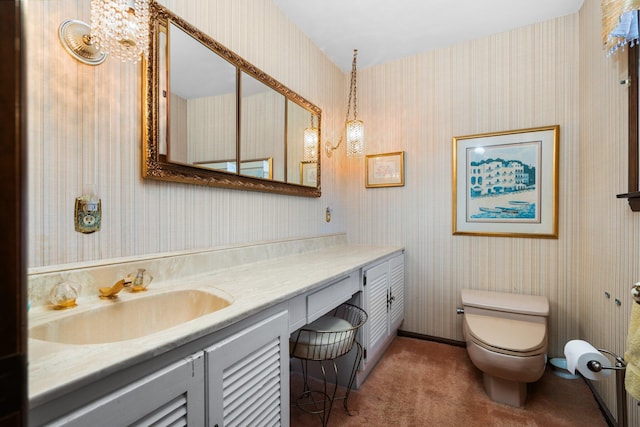 bathroom with wallpapered walls, toilet, and vanity