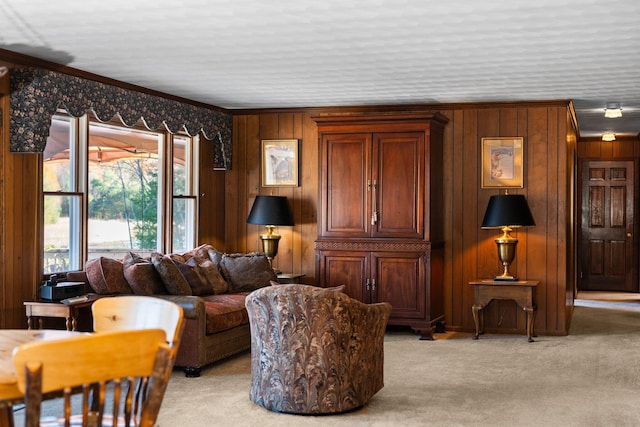 living room featuring wooden walls, ornamental molding, and light carpet