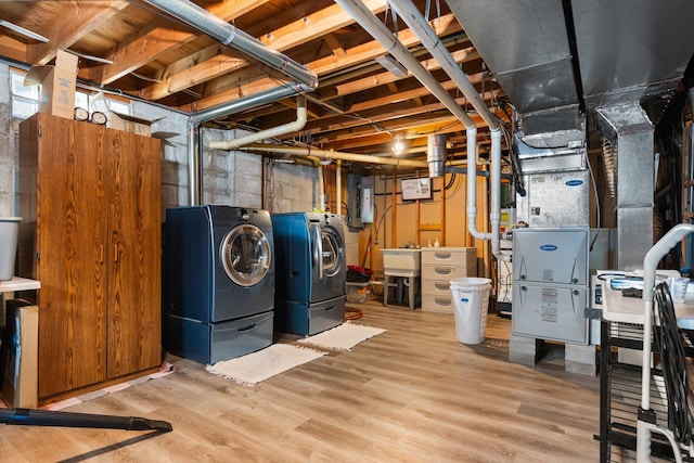 unfinished below grade area featuring a sink, wood finished floors, and washing machine and dryer