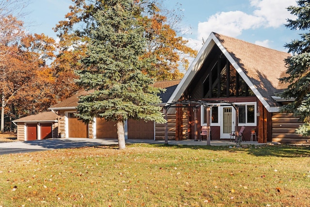 view of front of property featuring a shingled roof, log exterior, concrete driveway, a front yard, and a garage