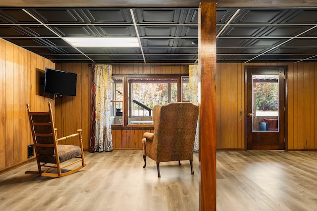 living area with a wealth of natural light, wood finished floors, wood walls, and an ornate ceiling