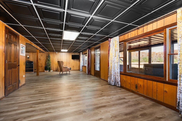 basement with wood walls, an ornate ceiling, and wood finished floors