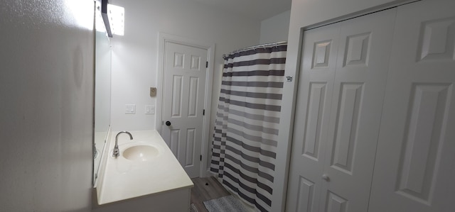 bathroom with vanity, curtained shower, and wood finished floors