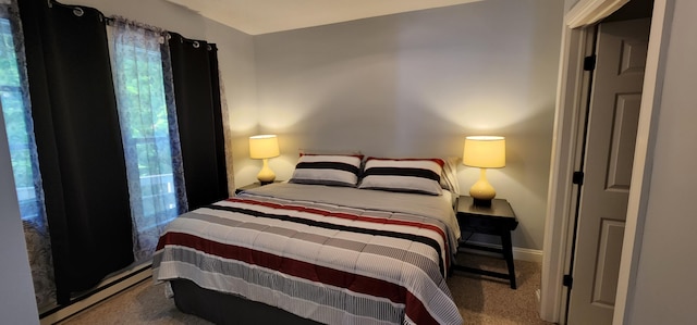 carpeted bedroom with a baseboard radiator and baseboards