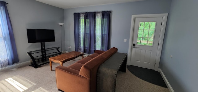 carpeted living room featuring baseboards