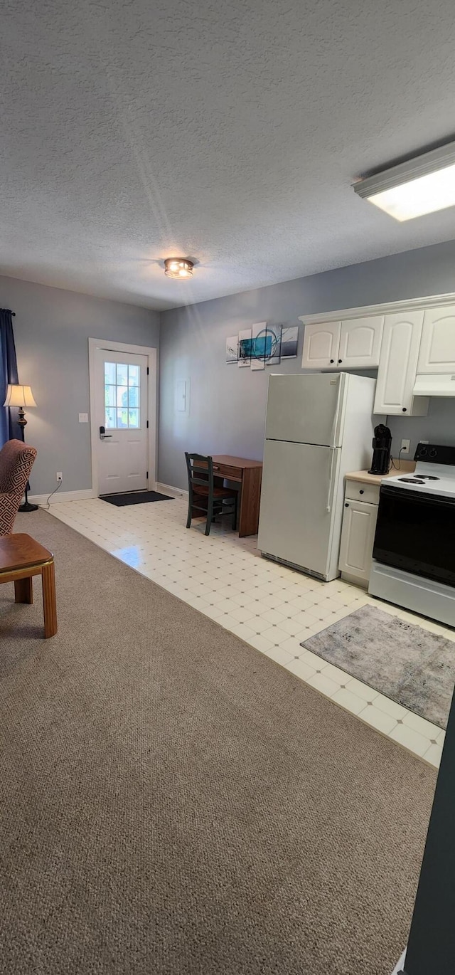 kitchen featuring a textured ceiling, freestanding refrigerator, white cabinets, electric stove, and light carpet