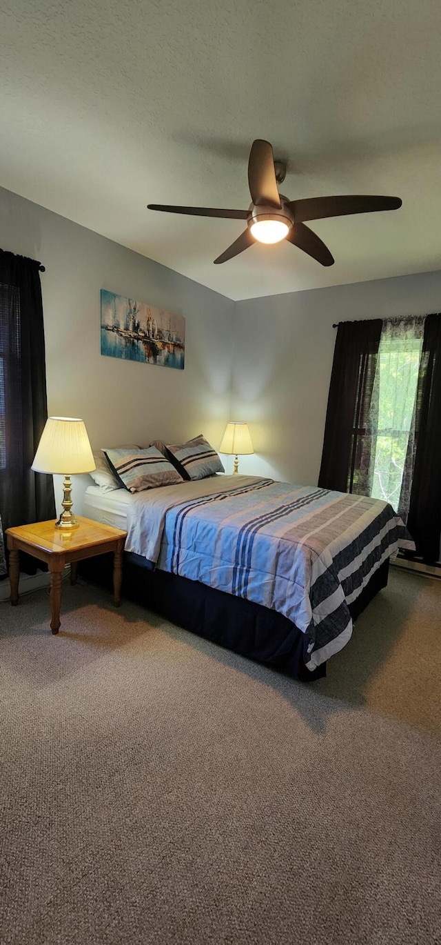 bedroom featuring carpet floors, a textured ceiling, and ceiling fan