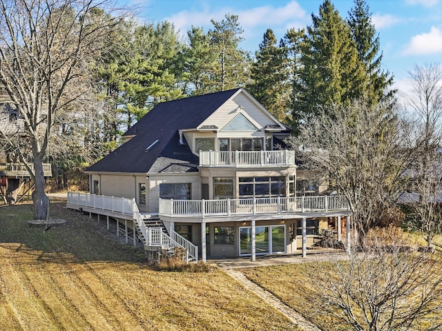 rear view of house with a deck, a balcony, stairway, and a shingled roof