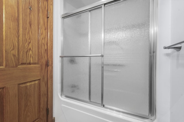 bathroom with bath / shower combo with glass door