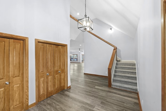 stairs featuring high vaulted ceiling, baseboards, and wood finished floors