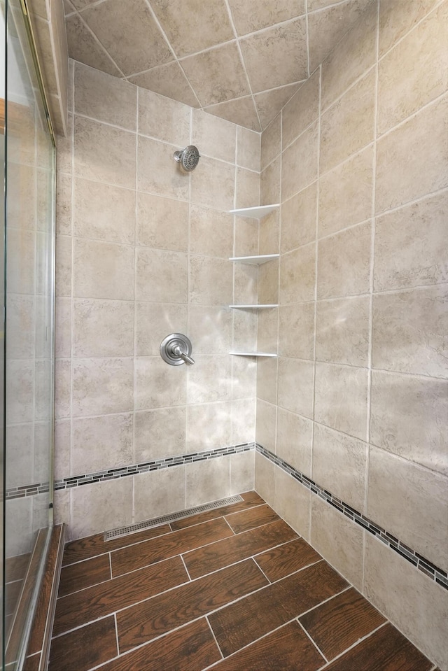 bathroom featuring a tile shower and wood finish floors