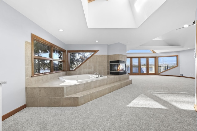 bathroom with a garden tub, recessed lighting, baseboards, and a tile fireplace