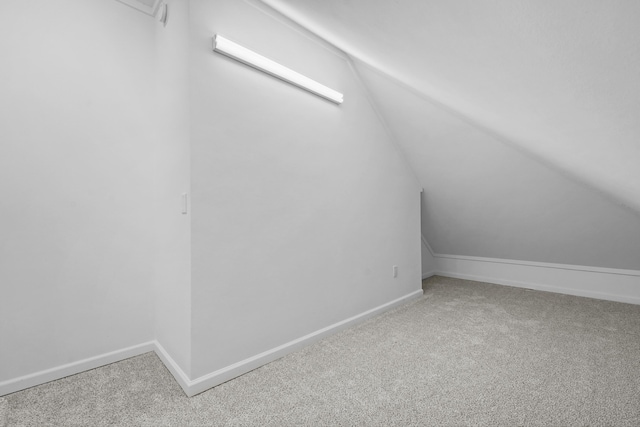 additional living space featuring lofted ceiling, baseboards, and carpet floors