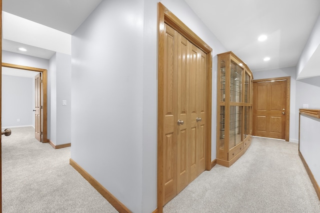 corridor featuring recessed lighting, light colored carpet, and baseboards