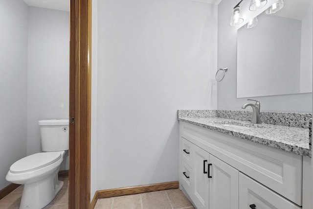 half bath with tile patterned floors, baseboards, toilet, and vanity