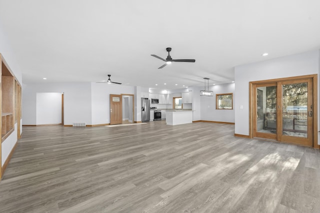 unfurnished living room featuring a ceiling fan, visible vents, baseboards, recessed lighting, and light wood-type flooring