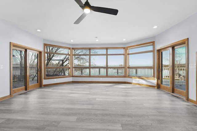 unfurnished living room featuring a wealth of natural light and wood finished floors