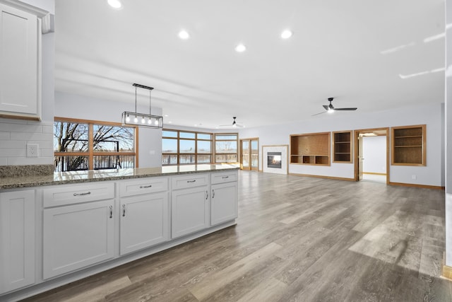 kitchen featuring recessed lighting, a peninsula, a ceiling fan, and light wood-style floors