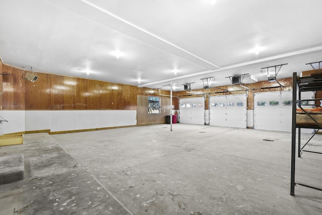 garage featuring wooden walls and a garage door opener