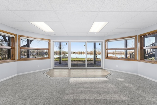 spare room featuring a wealth of natural light, a drop ceiling, baseboards, and carpet flooring